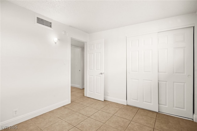 unfurnished bedroom with a closet and light tile patterned flooring