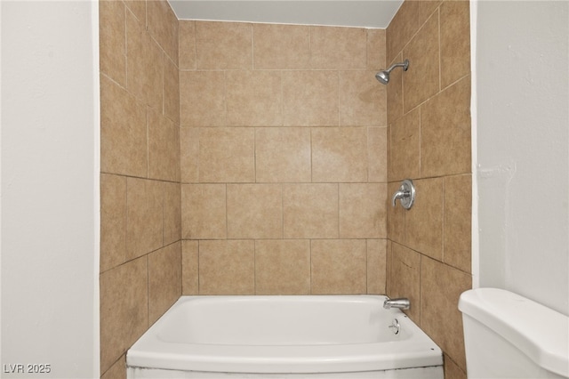 bathroom featuring tiled shower / bath combo and toilet