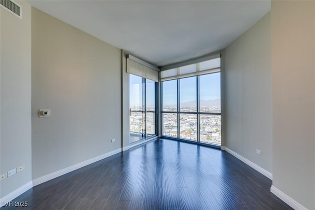 unfurnished room featuring dark hardwood / wood-style floors and floor to ceiling windows