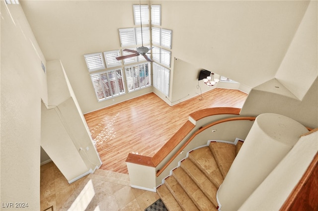 stairs featuring ceiling fan with notable chandelier, tile patterned floors, and a healthy amount of sunlight