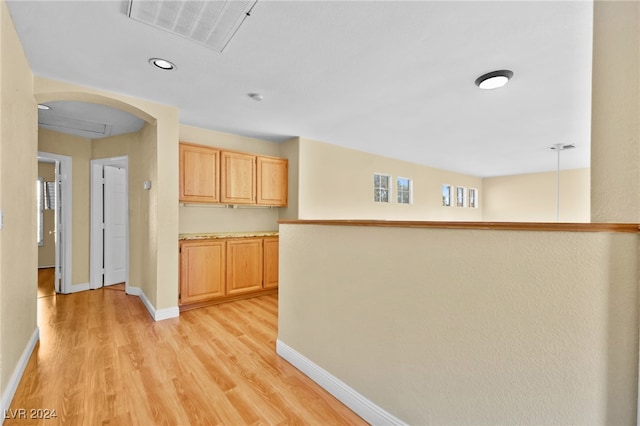 kitchen featuring decorative light fixtures, light hardwood / wood-style floors, and light brown cabinetry