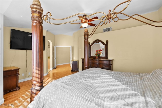 bedroom featuring decorative columns, light hardwood / wood-style flooring, and lofted ceiling