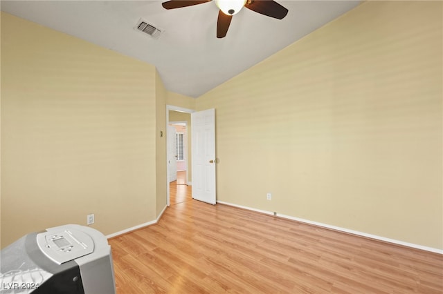 empty room with ceiling fan, vaulted ceiling, and light wood-type flooring