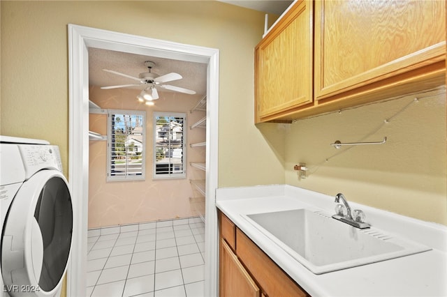 clothes washing area with cabinets, ceiling fan, sink, washer / dryer, and light tile patterned flooring