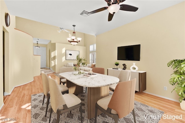 dining area featuring ceiling fan with notable chandelier and light wood-type flooring