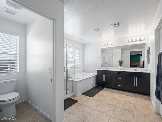 full bathroom featuring vanity, a textured ceiling, separate shower and tub, tile patterned flooring, and toilet