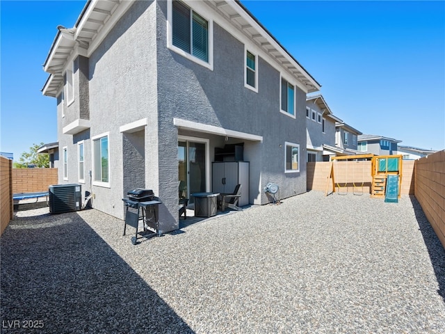 back of property with a playground, a patio area, and cooling unit