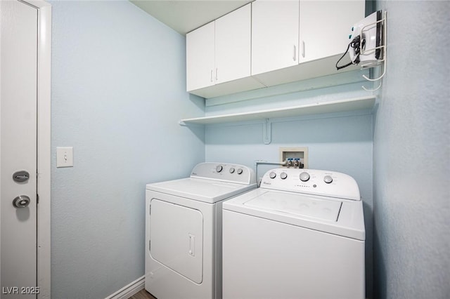 washroom with cabinets and washing machine and clothes dryer