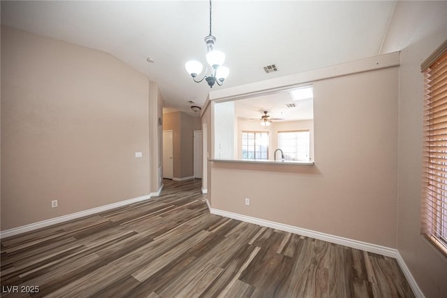 interior space with ceiling fan with notable chandelier, dark hardwood / wood-style flooring, sink, and vaulted ceiling