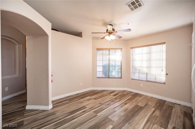 spare room featuring ceiling fan and dark wood-type flooring