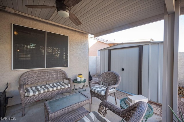 view of patio featuring ceiling fan, an outdoor hangout area, and a storage shed