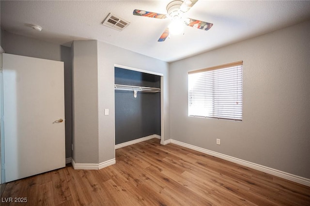 unfurnished bedroom featuring ceiling fan, light wood-type flooring, and a closet