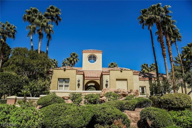 mediterranean / spanish-style home featuring a tile roof and stucco siding