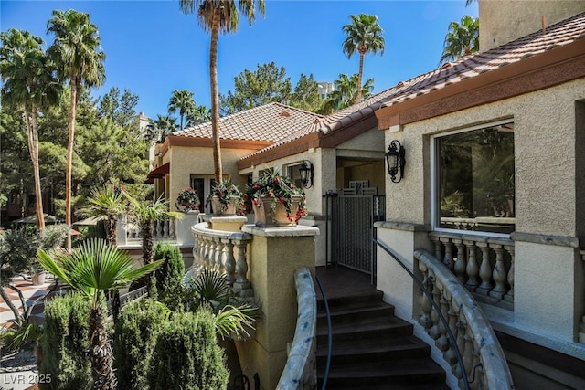 exterior space featuring a tiled roof and stucco siding