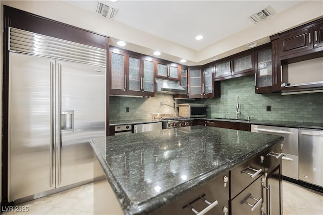 kitchen with appliances with stainless steel finishes, a sink, visible vents, and under cabinet range hood