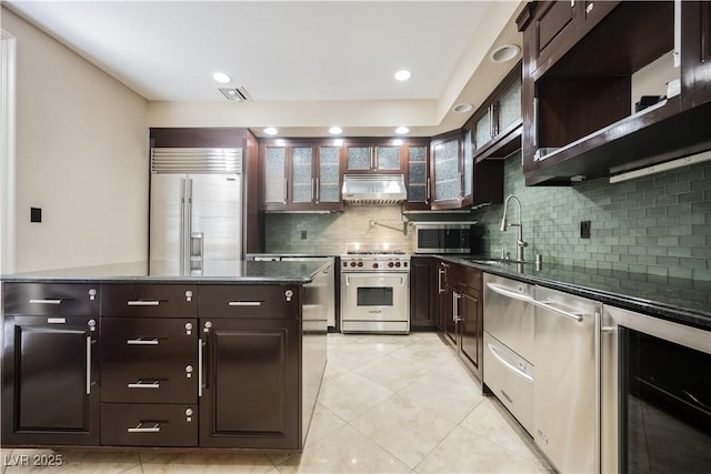 kitchen featuring beverage cooler, visible vents, high end appliances, a kitchen island, and a sink