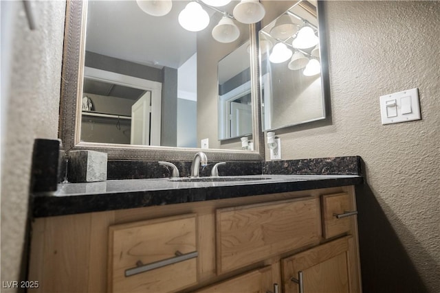 bathroom featuring a textured wall and vanity