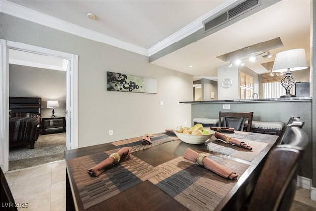 dining area with light tile patterned floors, visible vents, and crown molding