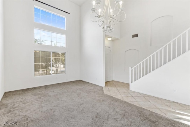 tiled foyer entrance featuring a notable chandelier and a high ceiling