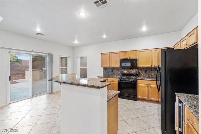 kitchen featuring a kitchen island, dark stone counters, decorative backsplash, light tile patterned flooring, and black appliances