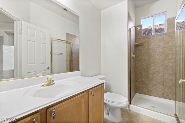 bathroom with toilet, vanity, tile patterned floors, and a shower with door