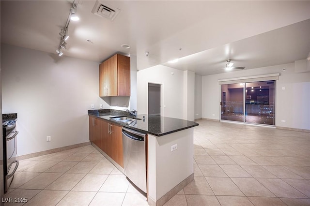 kitchen with kitchen peninsula, sink, light tile patterned floors, and appliances with stainless steel finishes