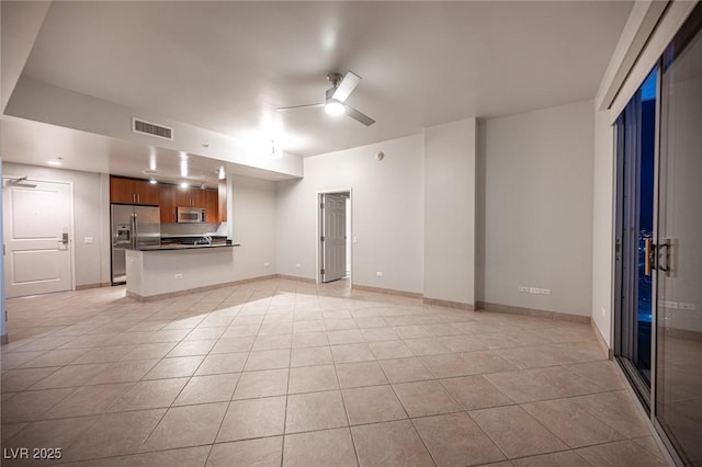 unfurnished living room with light tile patterned floors and ceiling fan