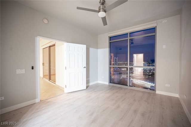 empty room with ceiling fan and light hardwood / wood-style floors