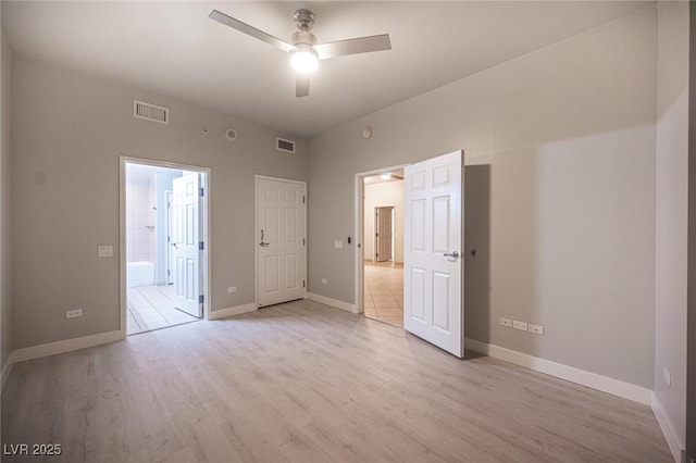 unfurnished bedroom featuring ceiling fan, light wood-type flooring, and ensuite bath