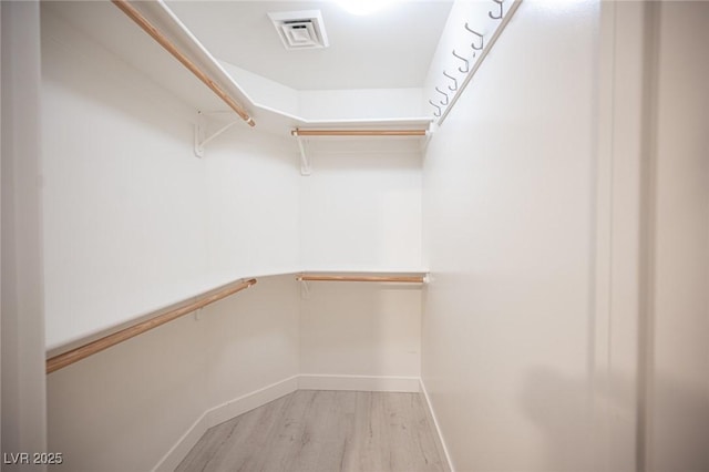 walk in closet with light wood-type flooring