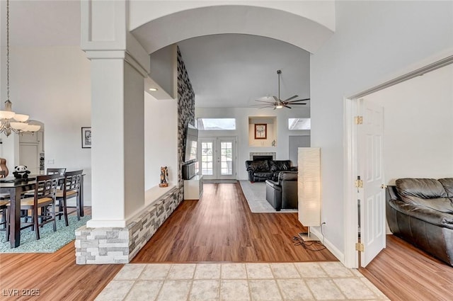 hallway with french doors, high vaulted ceiling, and wood-type flooring