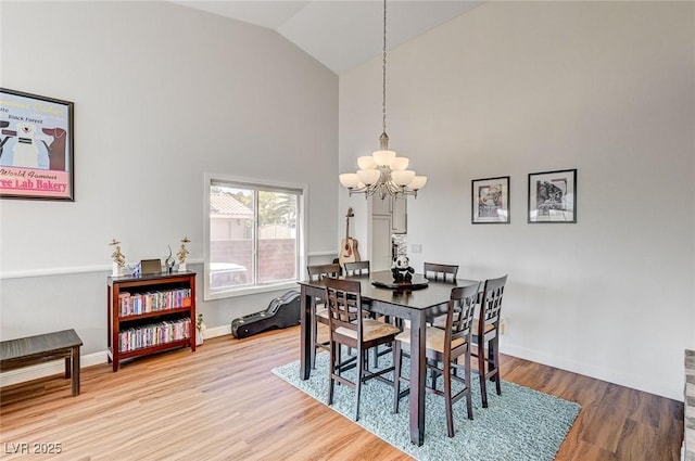 dining room with hardwood / wood-style floors, lofted ceiling, and a notable chandelier