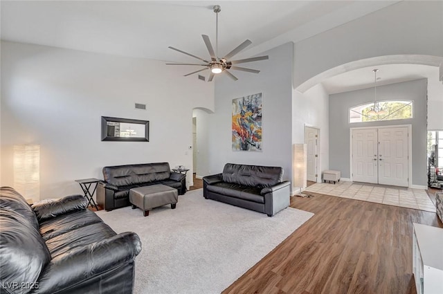 living room with ceiling fan, high vaulted ceiling, and light wood-type flooring