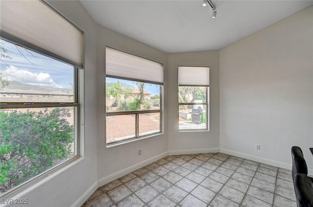 unfurnished office featuring plenty of natural light and rail lighting