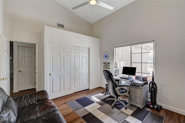 home office with ceiling fan, dark hardwood / wood-style flooring, and high vaulted ceiling