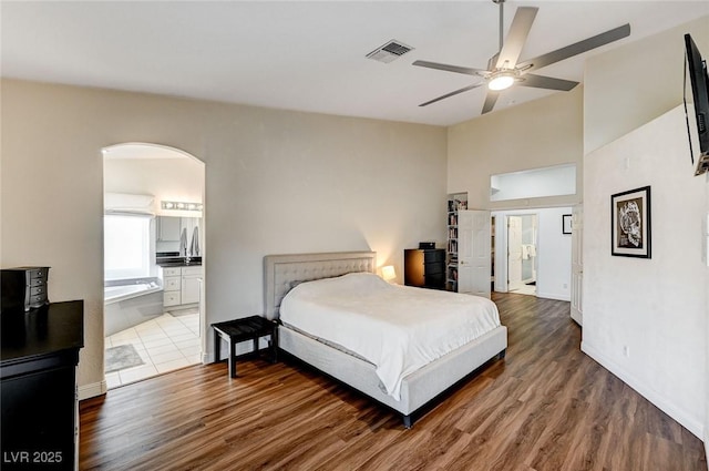 bedroom featuring connected bathroom, ceiling fan, and wood-type flooring