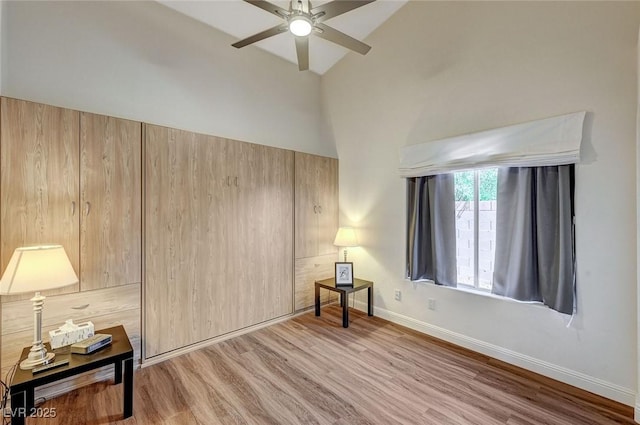 bedroom with ceiling fan, light hardwood / wood-style flooring, and vaulted ceiling