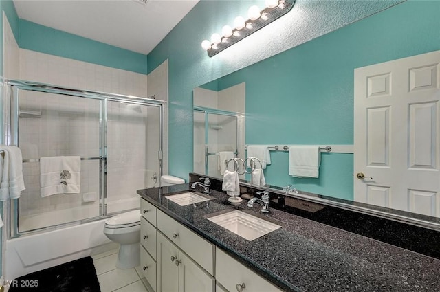 full bathroom featuring tile patterned flooring, vanity, toilet, and bath / shower combo with glass door