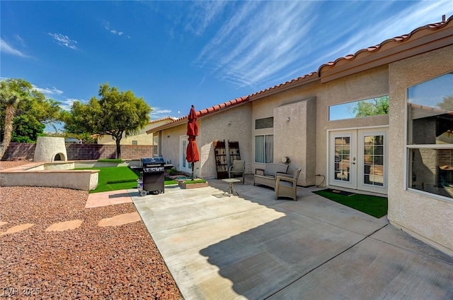 back of house with a patio area, exterior fireplace, and french doors