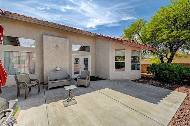 rear view of house featuring an outdoor living space, french doors, and a patio