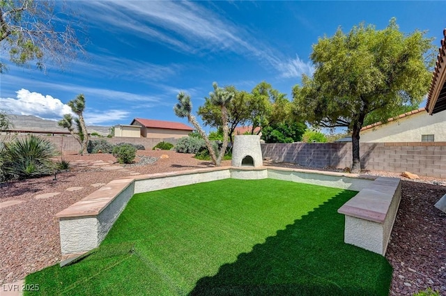 view of yard with exterior fireplace