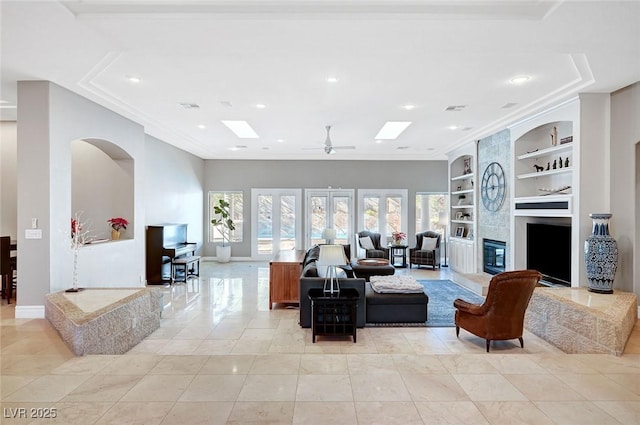 tiled living room featuring built in shelves, ceiling fan, and french doors