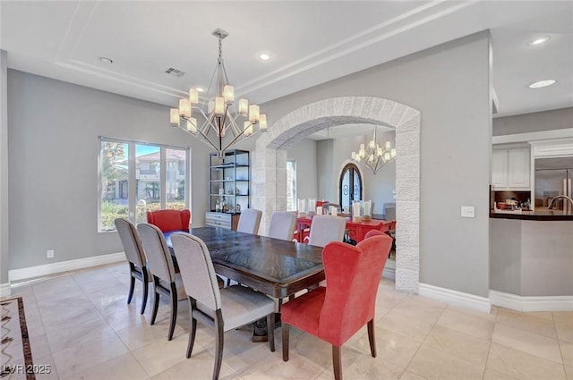 tiled dining space with a notable chandelier and a tray ceiling