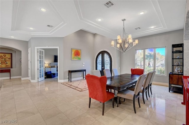 dining room with a notable chandelier, light tile patterned floors, a tray ceiling, and french doors