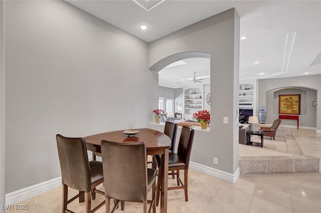 tiled dining room with ceiling fan and built in features