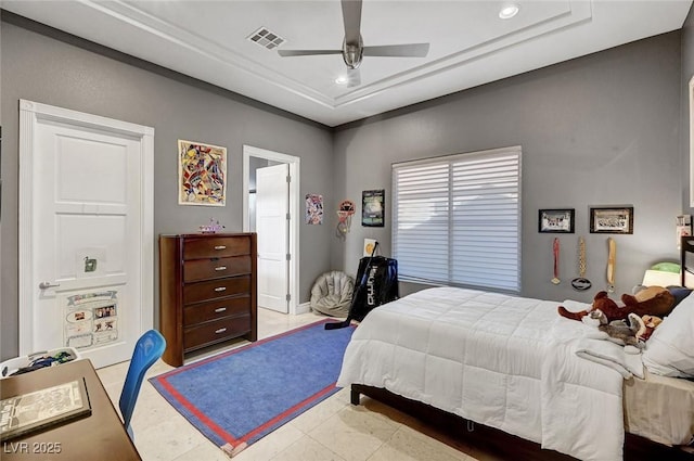 bedroom featuring a tray ceiling, ceiling fan, and light tile patterned flooring