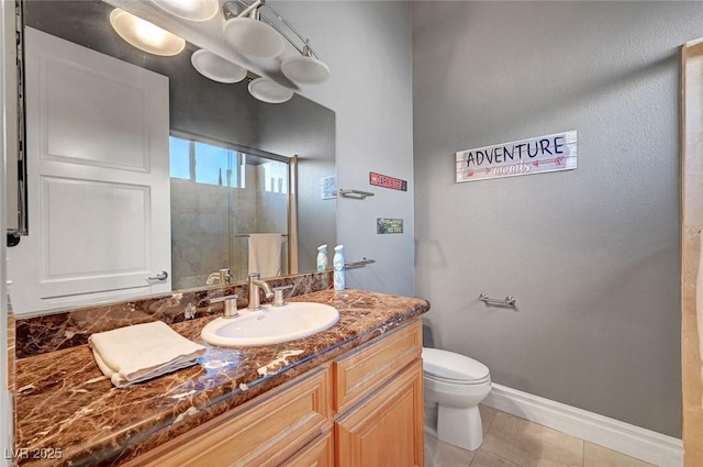 bathroom with tile patterned flooring, vanity, toilet, and a shower with shower door