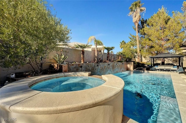 view of pool featuring a gazebo, an in ground hot tub, and pool water feature