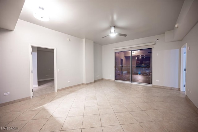 empty room with ceiling fan and light tile patterned flooring