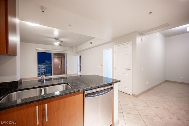 kitchen with ceiling fan, sink, light tile patterned floors, dark stone countertops, and dishwasher